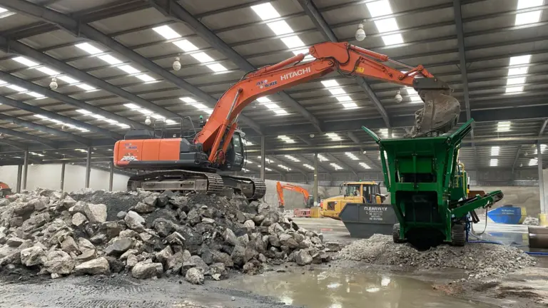 Crushing old concrete floor of warehouse