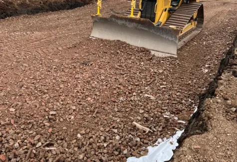 Grading stone with Dozer equipped with machine control for more accurate depth of stone layer to be achieved